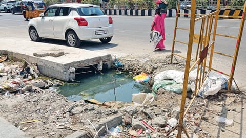 An uncovered drain with stagnated sewage and protruding iron rods posing threat to public