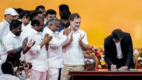 Newly-elected Tamil Nadu Chief Minister and Tamilaga Vettri Kazhagam (TVK) chief C Joseph Vijay signs documents during the TVK cabinet's swearing-in ceremony, at Jawaharlal Nehru Stadium, in Chennai, Sunday, May 10, 2026. Congress MP and Lok Sabha LoP Rahul Gandhi is also present 