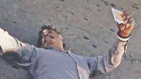 man layaing on road