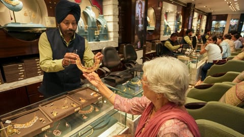 A customer checks a necklace at a jewellery shop, in Amrisar, Punjab, Wednesday, May 13, 2026