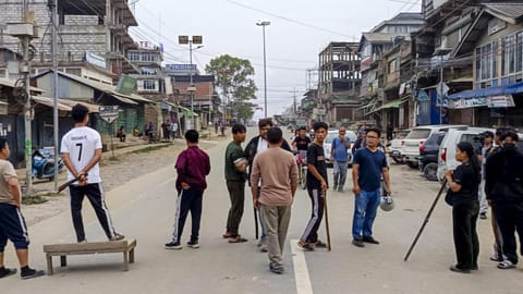 People block a road after the normal life was hit by shutdowns called by the Kuki Zo and Naga communities against the killing of three church leaders and a civilian on Wednesday in Kangpokpi, in Churachandpur, Manipur, on Thursday, May 14, 2026 