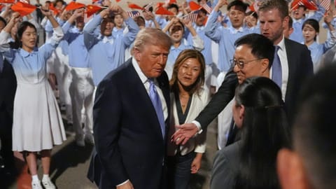US President Donald Trump talks during an arrival ceremony Wednesday, May 13, 2026, at Beijing Capital International Airport in Beijing, with Eric Trump, right.