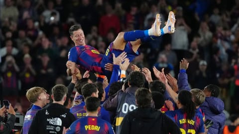 Barcelona's Robert Lewandowski is thrown into the air by his teammates after his last game for the club at the end of the Spanish La Liga soccer match between FC Barcelona and Real Betis in Barcelona, Spain