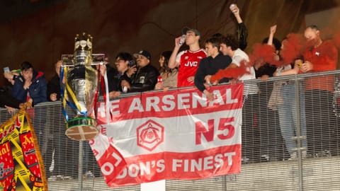 Arsenal fans celebrate with a miniature Premier League trophy