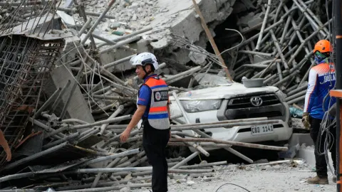 Rescuers stand beside ruins as search operations continue at a collapsed building in Angeles city in Pampanga province, north of Manila, Monday, May 25, 2026. (AP Photo/Aaron Favila)