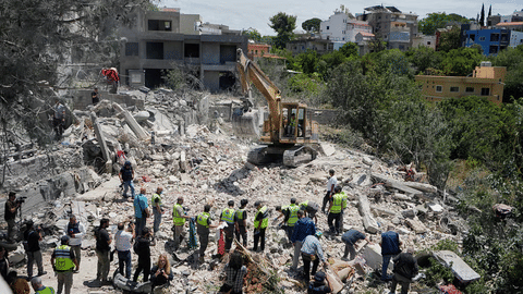 Rescue workers search for victims in the rubble of a destroyed house that was hit on Tuesday by an Israeli airstrike, in the village of Deir Qanoun al Nahr, south Lebanon, Wednesday, May 20, 2026