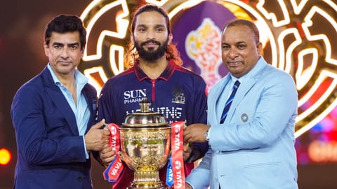 BCCI President Mithun Manhas, left, and Secretary Devajit Saikia, right, hand over the tournament trophy to Royal Challengers Bengaluru's captain Rajat Patidar during the presentation ceremony after winning the Indian Premier League