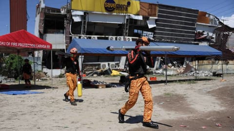 Rescuers prepare their equipment for a search operation at a damaged building following an earhtquake 