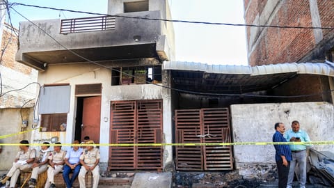 Police officials at the site after a fire broke out in a factory operated in a small house in Jaipur's Kho-Nagorian area
