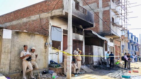 Police officials at the site after a fire broke out in a factory operated in a small house in Jaipur's Kho-Nagorian area