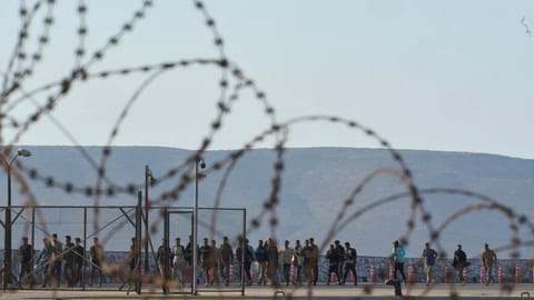 Migrants rescued south of Crete walk after their arrival at the the port of Lavrio, Greece