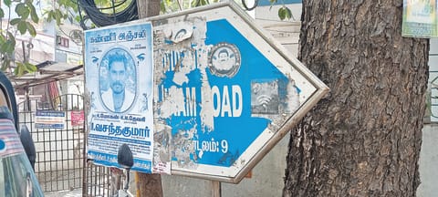 unauthorised posters being pasted on street name boards
