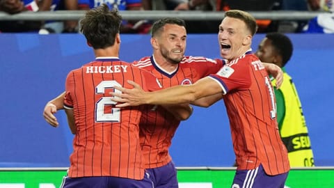 Scotland's John McGinn (7) celebrates with teammate's Aaron Hickey (2) and Lewis Ferguson (19) after scoring his teams first goal during the World Cup 