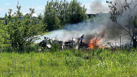 The wreckage of a plane crash burns in a field in Butler, Mo