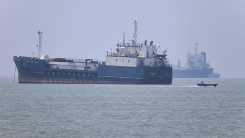 A small motorboat passes anchored vessels in the Strait of Hormuz 