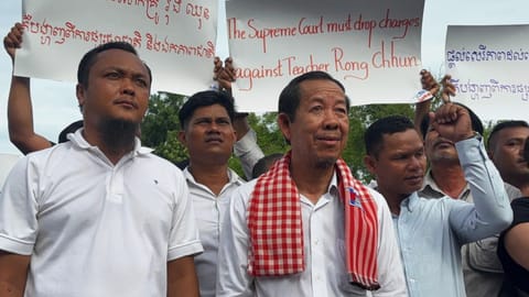 Rong Chhun, a top adviser to the Nation Power Party and a prominent opposition politician, stands with supporters outside Cambodia’s Supreme Court in Phnom Penh