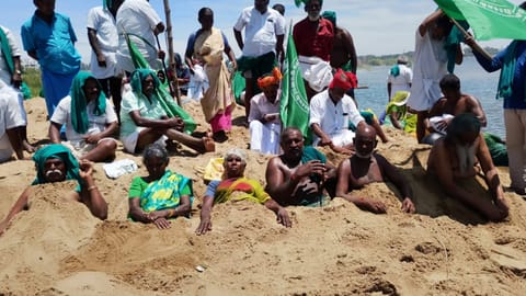 Protesting farmers bury themselves in the dry Cauvery river bed in Tiruchy on Tuesday


