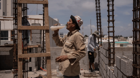 Jorge Moreno, a worker, drinks flavored water to cope with the heat wave during his workday at a construction site in Veracruz, Mexico, on June 17, 2024