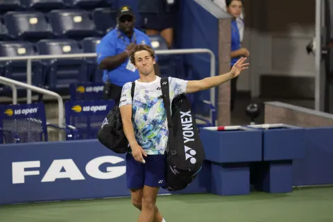 Casper Ruud, of Norway, acknowledges fans after losing to Zhizhen Zang, of China.