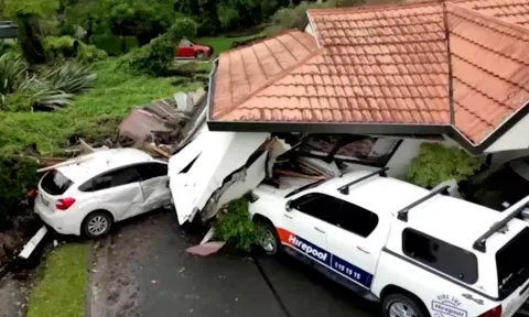 &nbsp;A view of a house that had collapsed on vehicles, following floods
