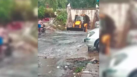 An earthmover clearing water out of an underpass in Ambur on Thursday
