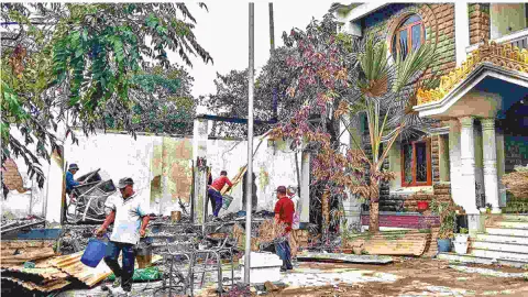 Workers attempt to salvage burnt items at Ranjan Singh’s residence in Imphal
