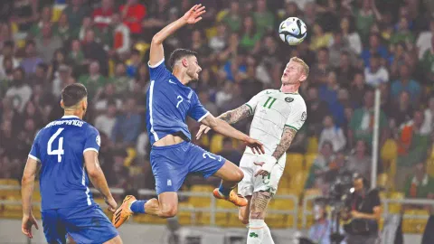 Ireland’s James McClean (right) fights for the ball with Greece’s Giorgos Masouras