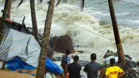 &nbsp;Locals gather near the debris of a house on the beach that was damaged by the rough sea during the ongoing monsoon season, in Kozhikode, Friday (Photo: PTI)