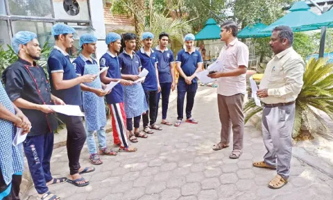 Labour Department officials interacting with migrant workers and handing over pamphlets