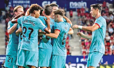 Barcelona players celebrate a goal against Osasuna FC
