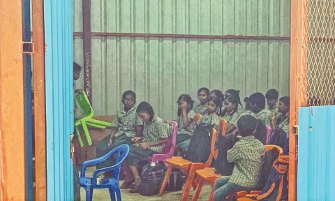 The temporary metal sheds inside the nearby school premises where some students have their classes.