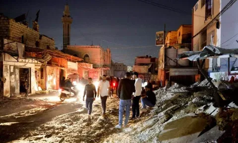 Palestinians stand on the street after an Israeli raid, in Jenin refugee camp in the Israeli-occupied West Bank. (Reuters)