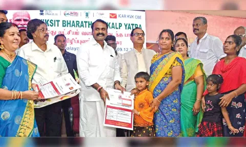 L Murugan distributing ‘selvamagal’ savings scheme to a child in Coimbatore
