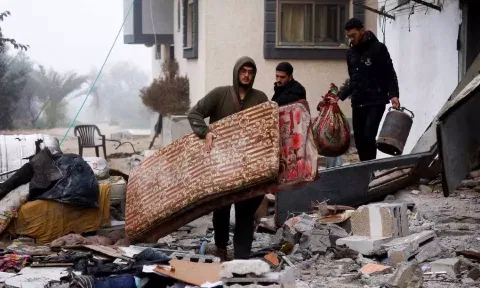 Palestinians carry belongings at the site of an Israeli strike on a house amid the ongoing conflict between Israel and the Palestinian Islamist group Hamas in Rafah in the southern Gaza Strip. (Reuters)