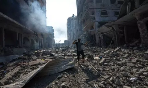 A Palestinian walks through the destruction by Israeli bombing in Gaza City (AP)&nbsp;