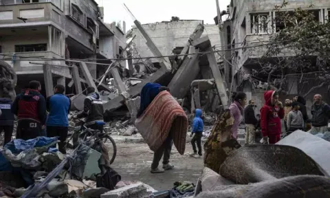 Palestinians inspect the damage of residential buildings after an Israeli airstrike in Rafah (AP)