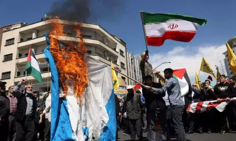 Iranians burn an Israeli flag during a rally marking Quds Day and the funeral of members of the Islamic Revolutionary Guard Corps who were killed in a suspected Israeli airstrike (Reuters)&nbsp;