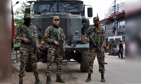 Security personnel stand guard infront of their armoured vehicle&nbsp;