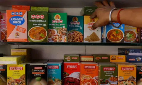A man adjusts the spice boxes of MDH and Everest on the shelf of a shop at a market in New Delhi (Reuters)