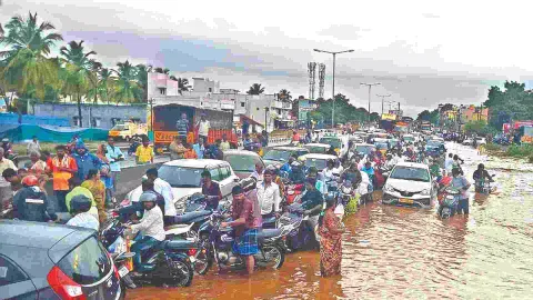 Motorist struggling to cross the inundated Salem-Madurai National Highway on Tuesday