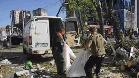 Municipal workers carry a dead body killed after an apartment building was hit by Russian air bomb killing at least three and injuring 23, in Kharkiv, Ukraine (Photo/AP)