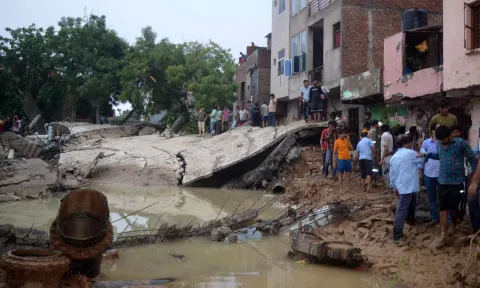 People near the debris after a water tank collapsed due to heavy rainfall, in Mathura