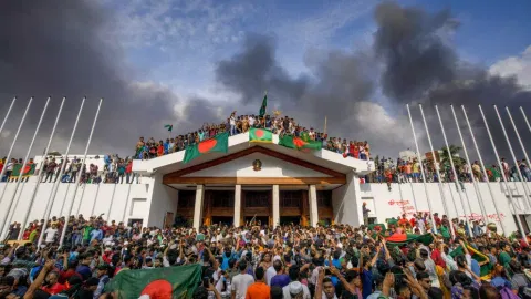 Bangladeshi people carry items from prime minister's house after they stormed into the premises, in Dhaka (PTI)