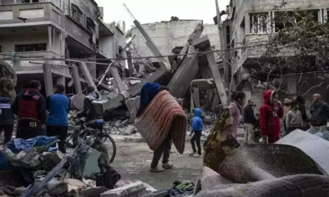 Palestinians inspect the damage of residential buildings after an Israeli airstrike
