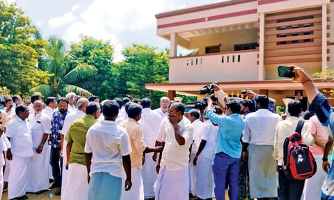 Supporters of R Vaithilingam gather outside his house at Thelungan Kudikadu in Thanjavur district