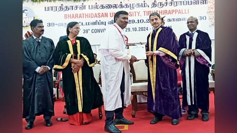 PhD scholar Israel Inbaraj handing over a petition to Governor Ravi during the Bharthidasan University convocation ceremony&nbsp;