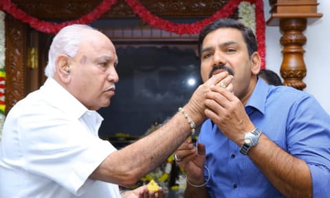 Karnataka BJP President B Y Vijayendra being offered sweets by his father B S Yeddyurappa on his birthday at their residence in Bengaluru (PTI)&nbsp;