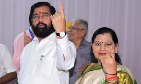 &nbsp;Maharashtra Chief Minister Eknath Shinde with his wife shows his ink-marked finger after casting vote during the state Assembly elections (PTI)