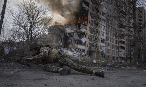 File image of A Ukrainian police officer takes cover in front of a burning building that was hit in a Russian airstrike in Avdiivka, Ukraine 