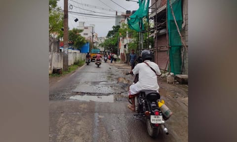 Motorists negotiate potholes on a narrow stretch&nbsp;